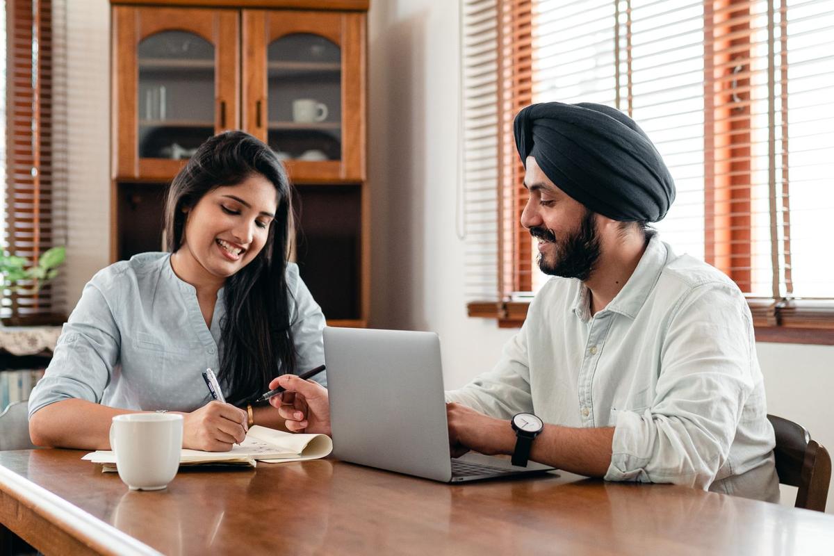 Two colleagues in an Indian office working together at a laptop