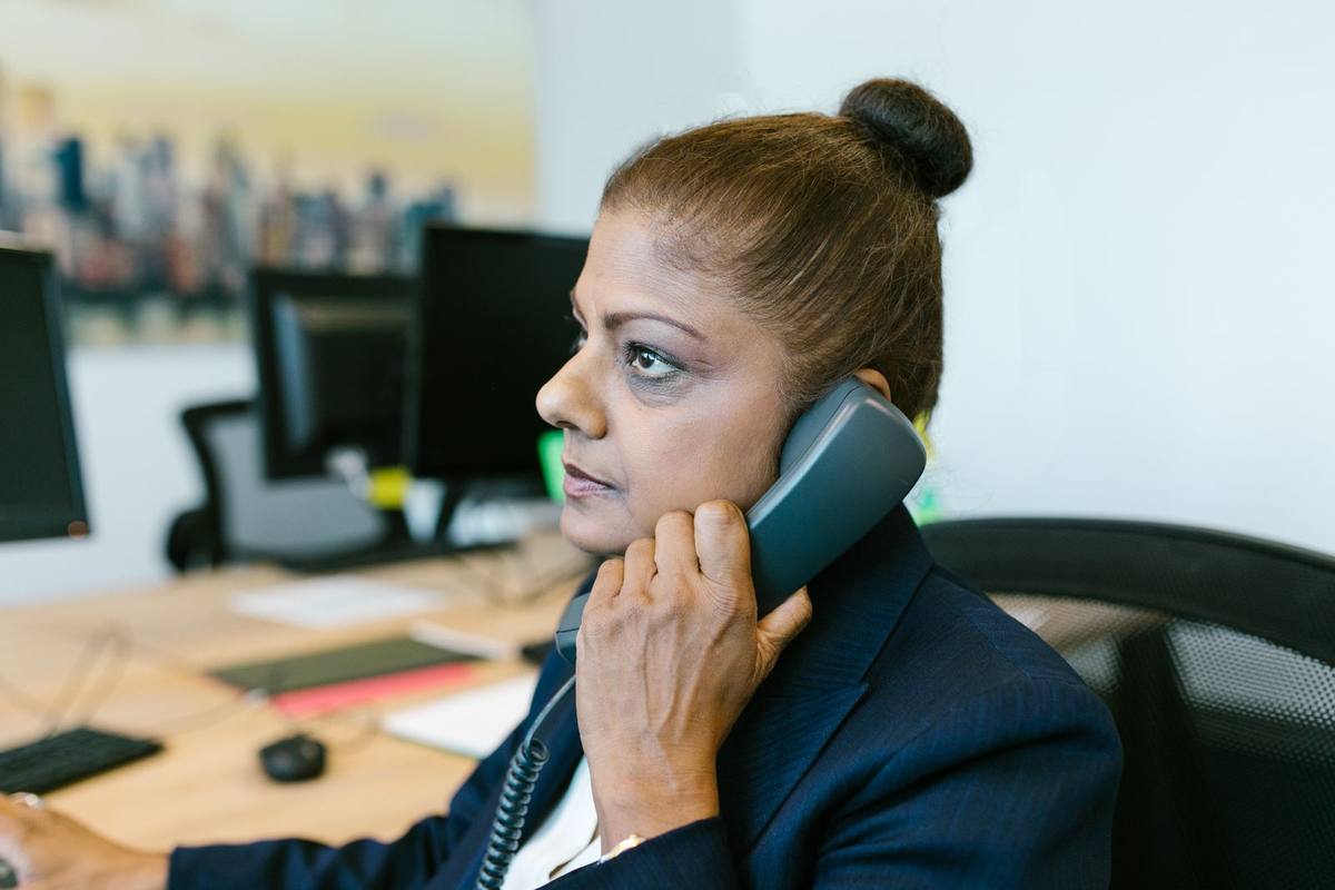 A businesswoman on the phone at her desk in an Indian office