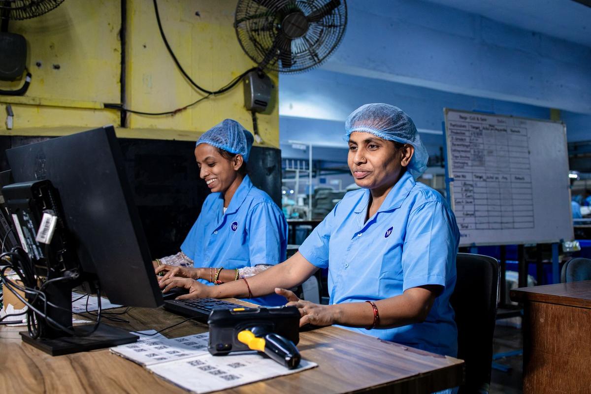 Two women working at computers in the office of an Indian factory