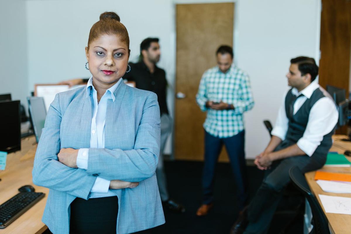 A businesswoman in an Indian office with colleagues working behind her